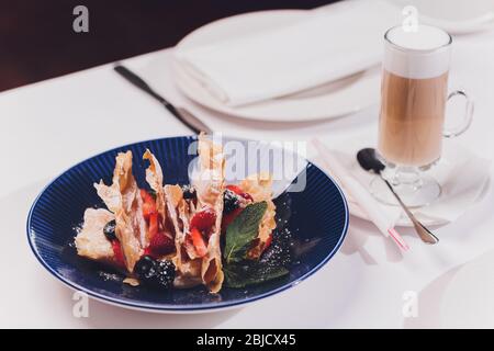 Französische dessert Blätterteig Blätterteig, überlagert mit Pudding Sahne, Himbeeren, Blaubeeren auf einem Schild an einer konkreten Tabelle, Ansicht von oben, in der Nähe Stockfoto