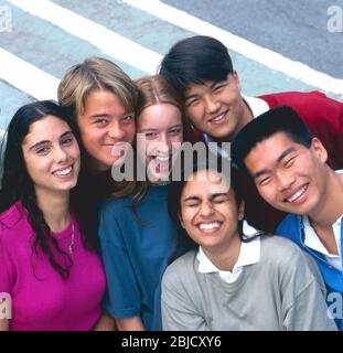 Schüler multikulturelle Gruppe von 6 glücklich attraktive Teenager-Senior School College High School multikulturelle Studenten in bunten T-Shirts Squash zusammen und posieren draußen in einer sonnigen Schule College Campus Umgebung Stockfoto