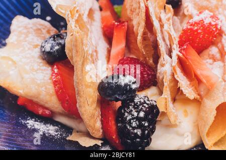 Französische dessert Blätterteig Blätterteig, überlagert mit Pudding Sahne, Himbeeren, Blaubeeren auf einem Schild an einer konkreten Tabelle, Ansicht von oben, in der Nähe Stockfoto