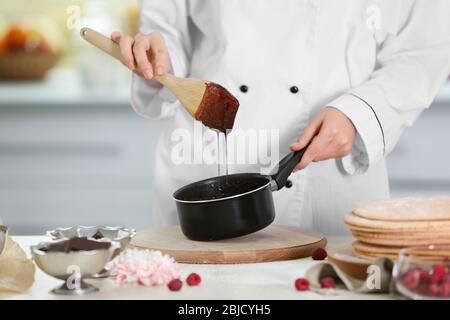 Kochkonzept. Professionelle Konditorei Herstellung Schokolade Zuckerguss Stockfoto