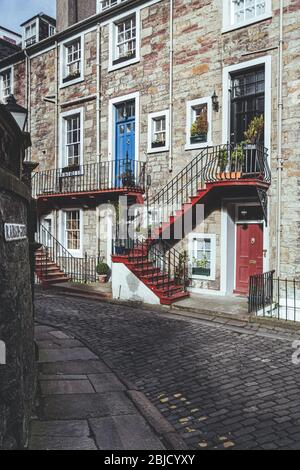 Bunte Eingangstüren an einer Fassade eines traditionellen Steinhauses in Ramsey Gardens, Altstadt von Edinburgh, Schottland Stockfoto