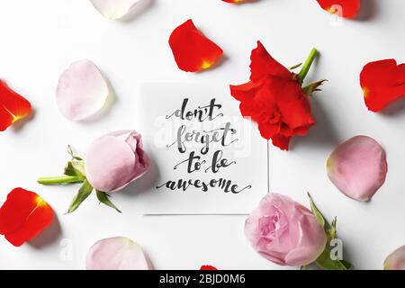 Zitat 'Vergiss nicht, ehrfürchtig zu sein' auf Papier mit Blütenblättern und Blumen geschrieben. Draufsicht Stockfoto