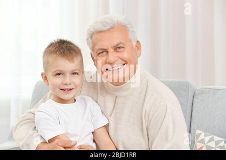 Glücklicher Großvater mit Enkel auf Couch Stockfoto
