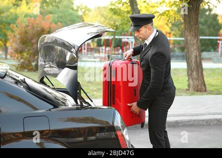 Chauffeur Koffer in Kofferraum setzen Stockfoto