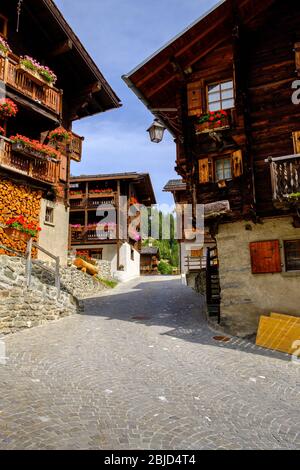 Grimentz, Wallis, Schweiz - 9. August 2018 : Straße im malerischen Alpendorf Grimentz im Val d'Anniviers mit traditionellen Holzhäusern Stockfoto