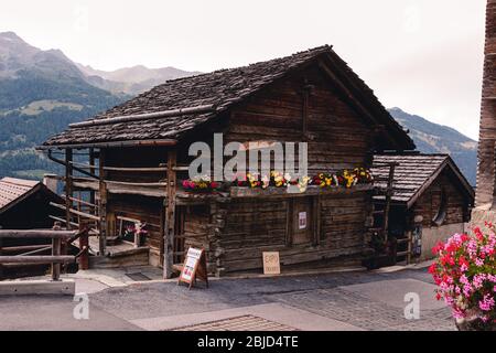 Saint-Luc, Wallis, Schweiz - 8. August 2018 : traditioneller Alpin-Holzbauernspeicher mit Blumen Stockfoto