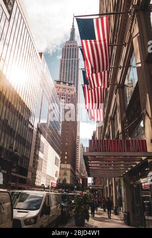 Amerikanische Flaggen mit Empire State Building im Hintergrund, in Manhattan, New York Stockfoto