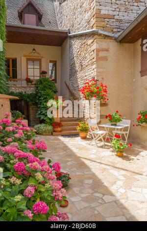 Burgund, Frankreich - 5. Juni 2010: Französisches Haus mit Blumen in einem Dorf in der Region Burgund, Frankreich Stockfoto