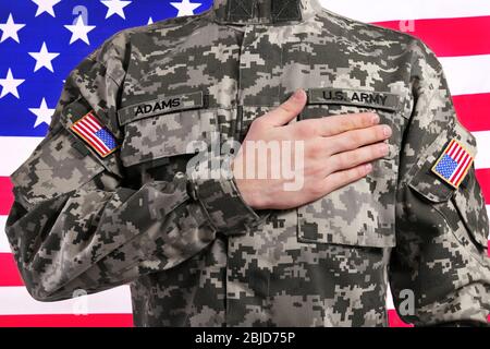 Soldat mit Hand auf Herz gegen US-Flagge Stockfoto