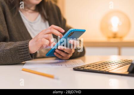 Frau, die zu Hause arbeitet. Mit einem Computer arbeiten. Frau mit Telefon Stockfoto