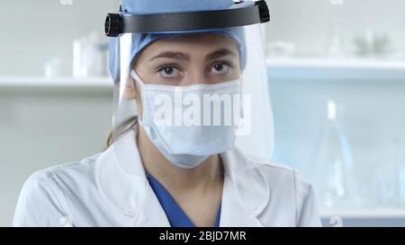 Weibliche Doktor trägt Gesichtsmaske und Schild Stockfoto