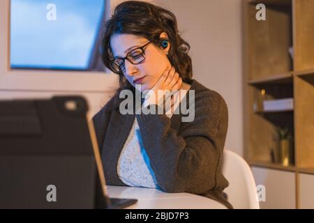 Frau, die zu Hause arbeitet. Mit einem Computer arbeiten. Frau Nackenschmerzen Stockfoto