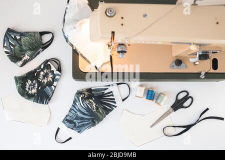 Schutzmaske Nähen Draufsicht. Herstellung von Hause aus Atemmaske, Corona Virenschutz. Home Arbeitsplatz des Nähen weiß backgrond Stockfoto