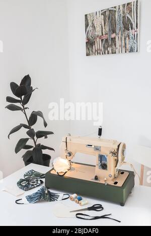 Arbeitsplatz von Seamis Nähen medizinische Schutzmaske zu Hause mit Vintage Nähmaschine weiß hintergrundet freien Raum für Text Stockfoto