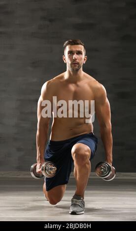 Sportlicher Mann macht Übungen mit Hanteln im Fitnessstudio Stockfoto