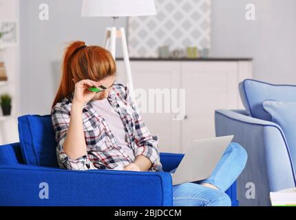 Verwirrt junge Frau Berechnung Steuern zu Hause Stockfoto