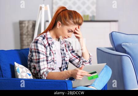 Verwirrt junge Frau Berechnung Steuern zu Hause Stockfoto