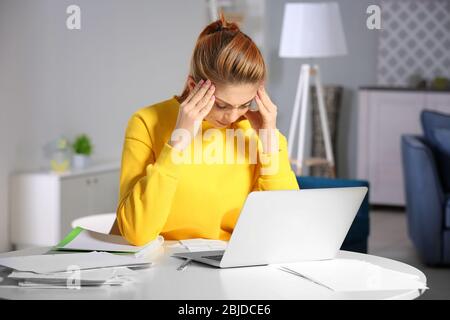Verwirrt junge Frau Berechnung Steuern zu Hause Stockfoto