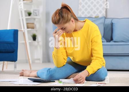 Verwirrt junge Frau Berechnung Steuern zu Hause Stockfoto