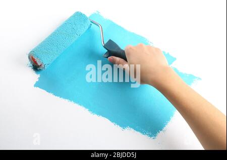 Weibliche Hand Malerei Wand mit Rolle Stockfoto