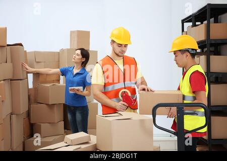 Arbeiter, die Pakete im Lager packen Stockfoto