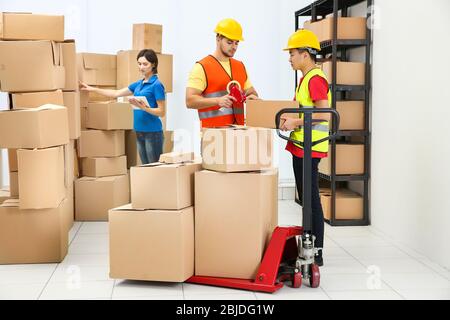 Arbeiter, die Pakete im Lager packen Stockfoto