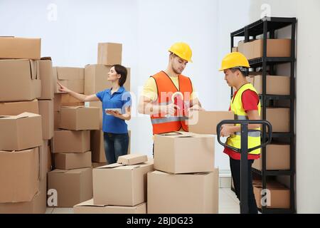 Arbeiter, die Pakete im Lager packen Stockfoto