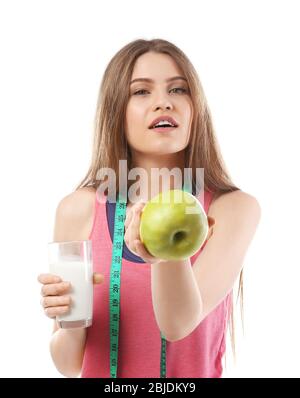 Schöne junge Frau mit Glas Milch, Apfel und Maßband auf weißem Hintergrund Stockfoto
