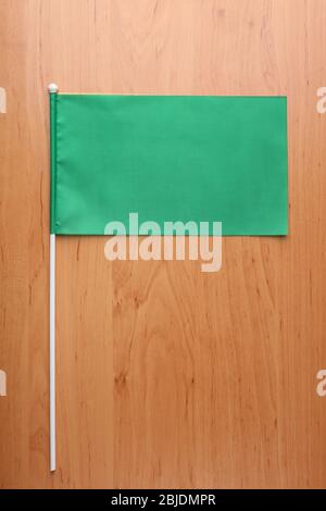 Grüne Flagge für das Branding auf Holztisch Stockfoto