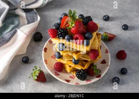 Traditionelle hausgemachte belgische Waffeln mit frischen Sommerbeeren, Heidelbeeren, Erdbeeren und Brombeeren. Leckeres Frühstück. Selektiver Fokus. Stockfoto