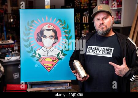 Hamm, 29. April 2020 - Corona Art. Graffiti-Künstler Kai 'Uzey' Wohlgemuth (Foto in seinem Atelier) widmete das Plakat 'Super Nurse', eine Krankenschwester mit Gesichtsmaske und Superman-Logo, den wahren Helden der Corona-Krise. --- Hamm, 29.4.2020 - Corona-Kunst. Das Poster „Super-Nurse“, eine Krankenschwester mit Mundschutz und Supermann-Logo, hat der Graffiti-Künstler Kai „Uzey“ Wohlgemuth (Foto in seinem Atelier) aus Hamm den echten Helden der Corona-Rise geweimet. Stockfoto