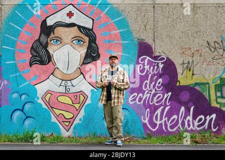 Hamm/Deutschland, 29. April 2020: Coronavirus-Graffiti des Straßenkünstlers Kai „Uzey“ Wohlgemuth (Foto) zeigt 'Super-Nurse' mit Schutzmaske an einer Wand in Hamm, Deutschland --- Hamm, 29.4.2020 - Corona-Kunst. Das Graffiti „Super-Nurse“ an einer Wand in Hamm. Eine Krankenschwester mit Mundschutz und Supermann-Logo hat der Graffiti-Künstler Kai „Uzey“ Wohlgemuth (Foto) aus Hamm den echten Helden in der Corona-Krise geweimet. Stockfoto