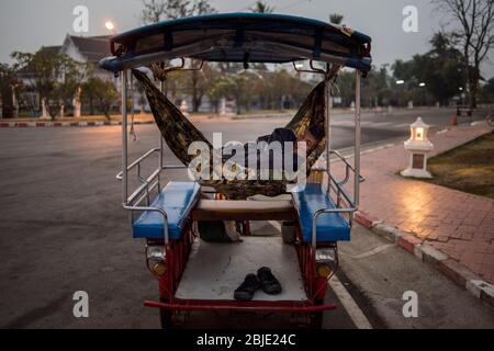 Ein Taxifahrer, der in seinem Fahrzeug schläft, Sukhothai, Thailand. Stockfoto