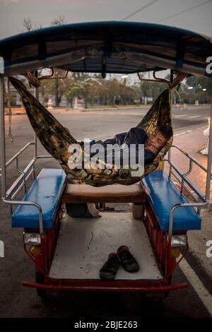 Ein Taxifahrer, der in seinem Fahrzeug schläft, Sukhothai, Thailand. Stockfoto