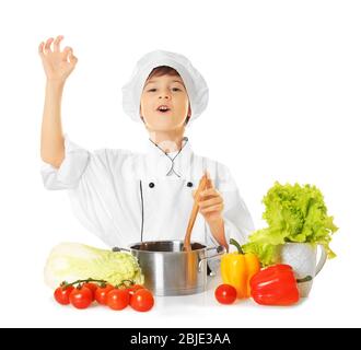 Niedlicher Junge in Koch Uniform Vorbereitung leckere Suppe, auf weißem Hintergrund Stockfoto