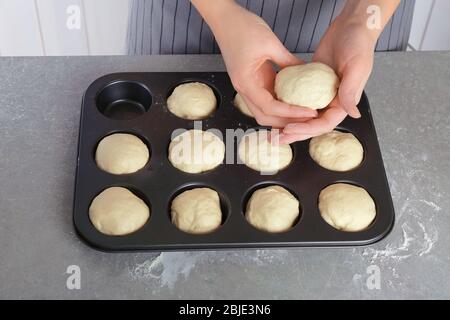 Weibliche Hände und Kugeln aus rohem Teig auf Küchentisch, aus nächster Nähe Stockfoto