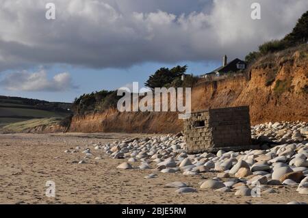 Pillendose des 2. Weltkriegs, auf einer Klippe bei Praa Sands als Teil des Küstenschutzes in Cornwall gebaut. Aufgrund der Erosion an der Küste ist es jetzt am Strand. Stockfoto