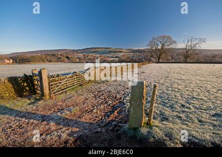 Frostige Felder in der Nähe von Baslow im Peak District National Park. Baslow Edge kann in der Ferne gesehen werden. Stockfoto