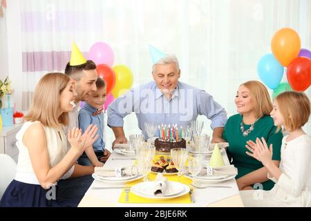 Familie feiert Großvater Geburtstag zusammen Stockfoto