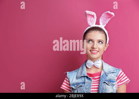 Schönes Mädchen mit Häschen Ohren auf farbigen Hintergrund Stockfoto