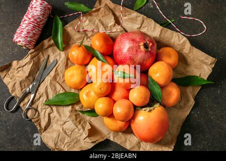 Set mit Mandarinen und Saftfrüchten auf Geschenkpapier Stockfoto