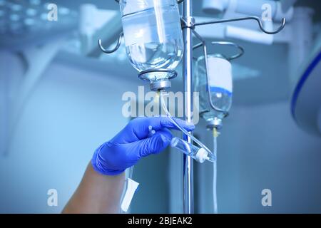 Des Arztes Hand und Infusion Tropf im Krankenhaus auf der Hintergrund jedoch unscharf Stockfoto