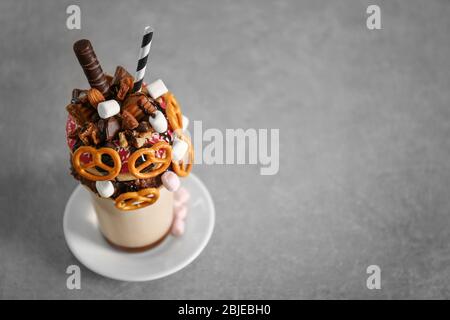 Milchshake, Donuts und andere Süßigkeiten in Glas auf farbigem Hintergrund Stockfoto