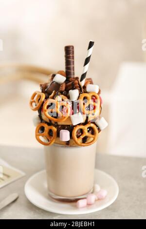 Milchshake, Donuts und andere Süßigkeiten in Glas auf dem Tisch Stockfoto