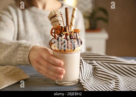 Mädchen mit Milchshake mit Donut und anderen Süßigkeiten im Glas Stockfoto