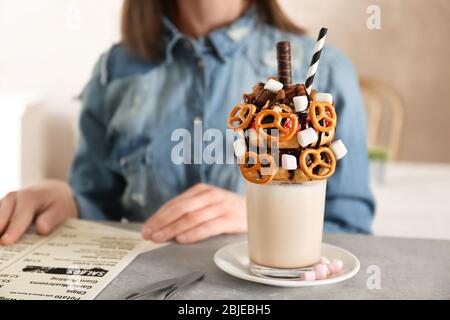 Milchshake, Donuts und andere Süßigkeiten in Glas auf dem Tisch Stockfoto