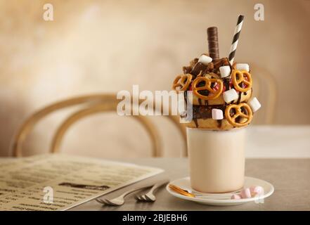 Milchshake, Donuts und andere Süßigkeiten in Glas auf dem Tisch Stockfoto