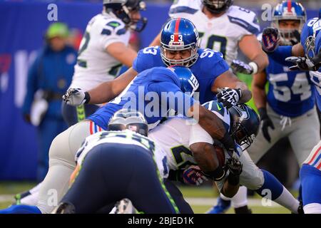 15. Dezember 2013: Seattle Seahawks laufen zurück Robert Turbin (22) wird von New York Giants defensive Ende Justin Tuck (91) und New York Giants d Stockfoto