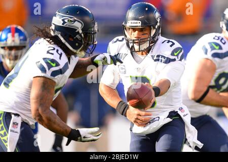 15. Dezember 2013: Seattle Seahawks Quarterback Russell Wilson (3) übergibt sich an Seattle Seahawks, die während des ersten hal Marshawn Lynch (24) zurücklaufen Stockfoto