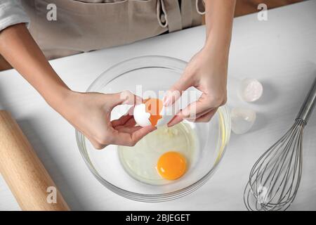 Frau Risse Eier in Glasschale Stockfoto